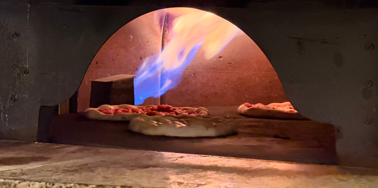 Le pizze nel forno, con la fiamma accesa